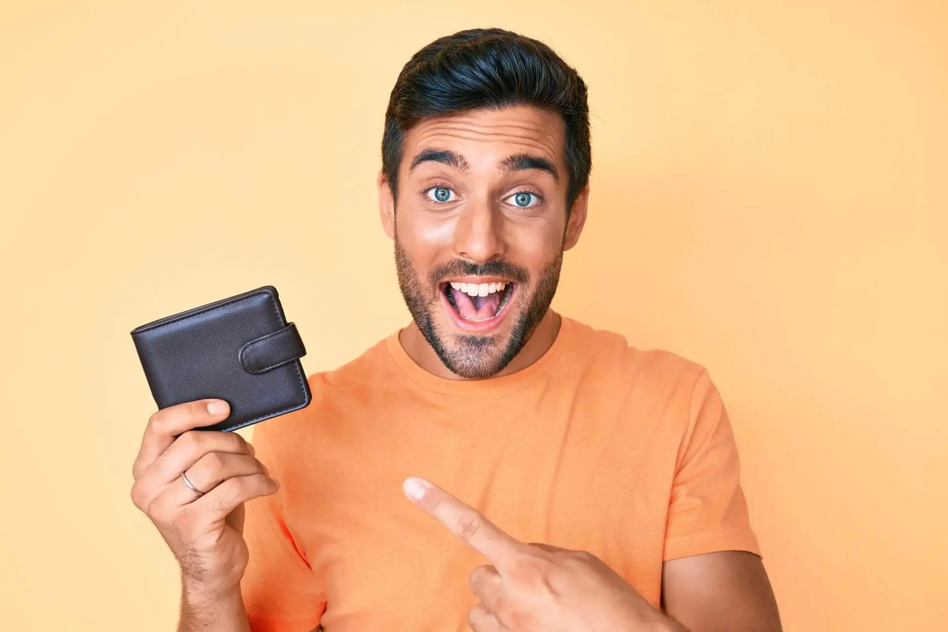 Young hispanic man holding leather wallet smiling
