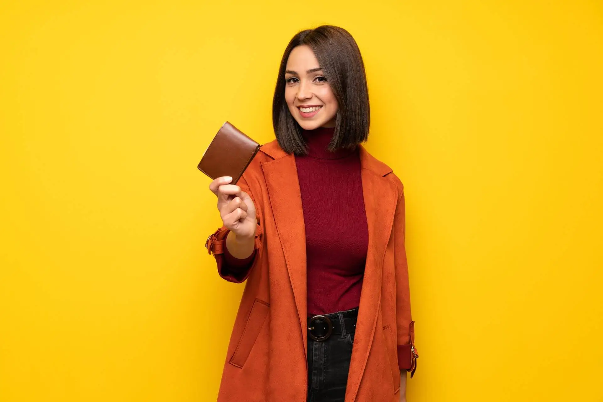 Young woman with coat holding a wallet