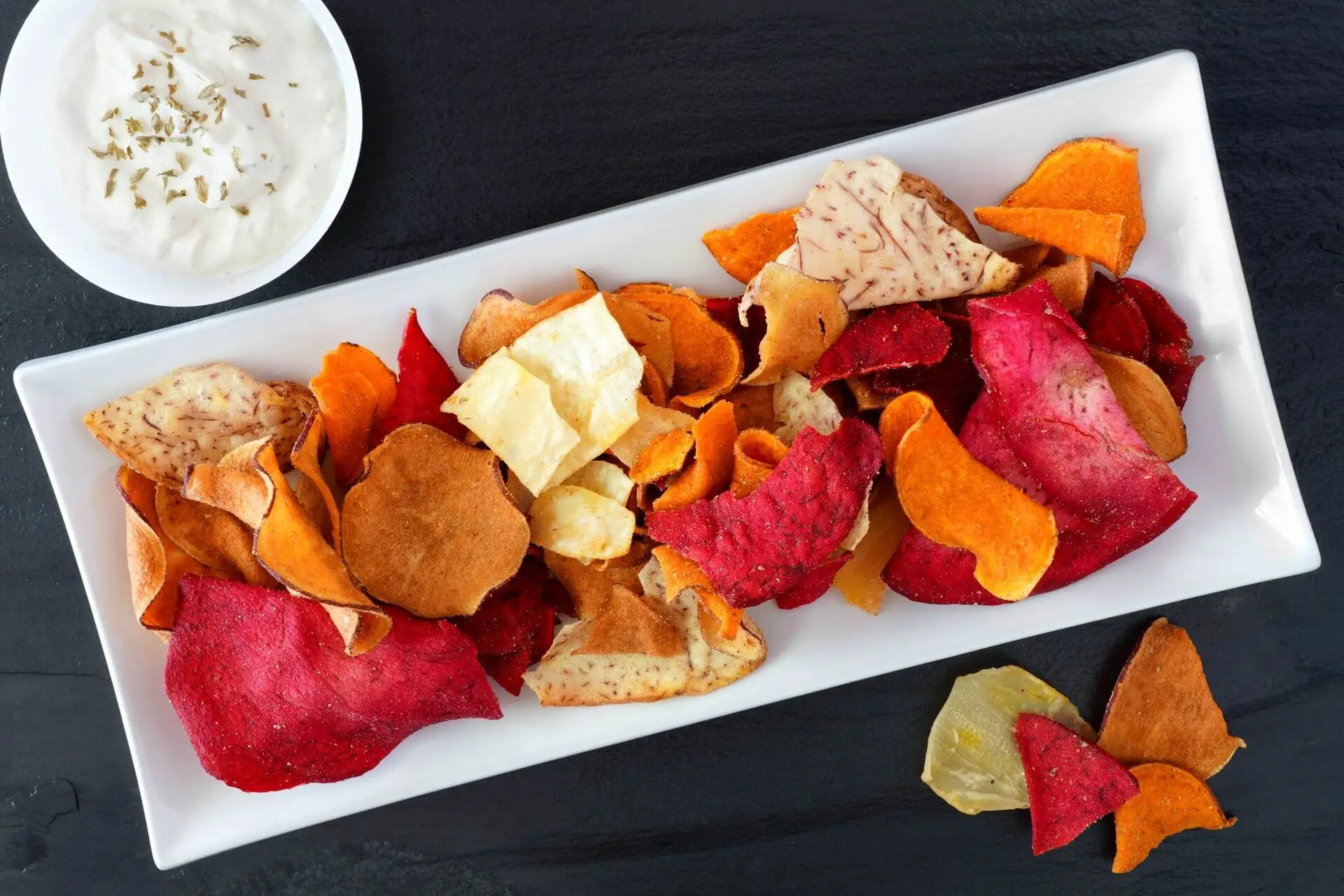 plate of colorful healthy vegetable chips with dip